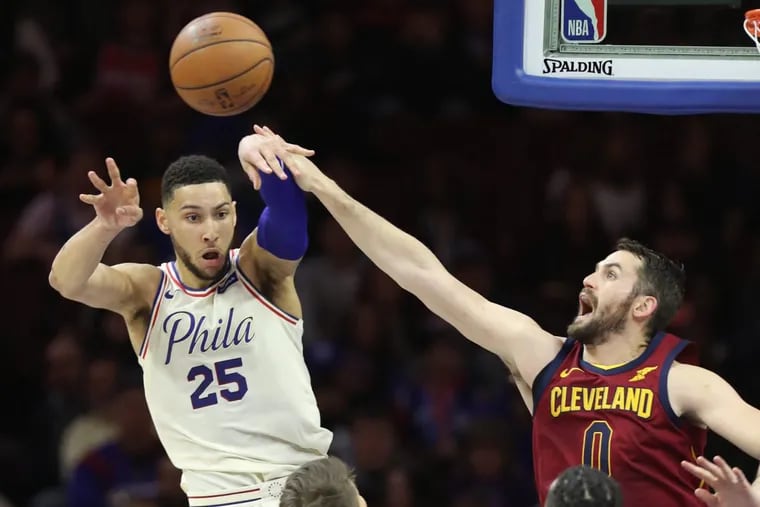 Ben Simmons, left, of the Sixers passes to a teammate after driving the lane while Kevin Love of the Cavaliers defends during the 2nd half at the Wells Fargo Center on April 6, 2018.