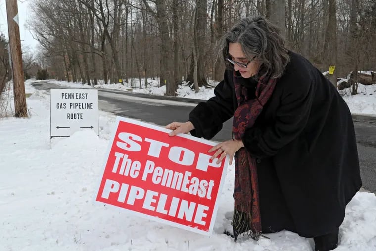 Alix Bacon adjusts an anti-pipeline placard in January 2015 in Hunterdon County, N.J., near where the proposed PennEast pipeline, considered in April by the U.S. Supreme Court, would cross the road.