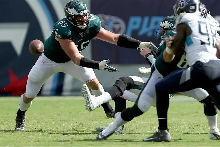 Eagles' Lane Johnson, left, tries to help Carson Wentz, right, after Wentz fumbled the ball against the Titans. The Philadelphia Eagles lose 26-23 in overtime to the Tennessee Titans in Nashville, TN on September 30, 2018. DAVID MAIALETTI / Staff Photographer
