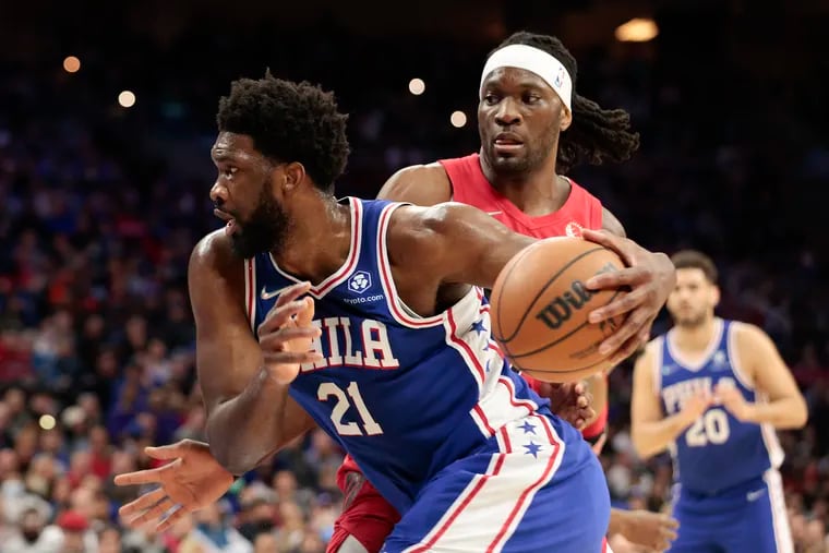 Sixers center Joel Embiid drives to the basket against Toronto Raptors forward Precious Achiuwa in the first quarter on Sunday, March 20, 2022 in Philadelphia.