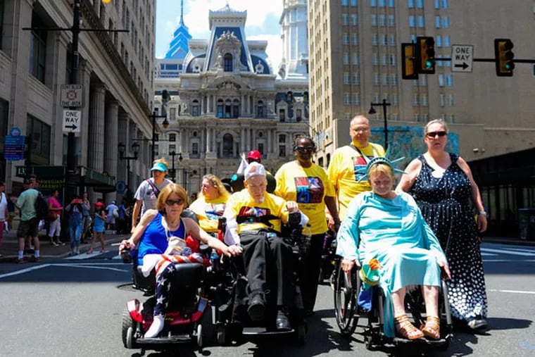 Participants lead the parade on Broad Street during the 25th anniversary of the Americans with Disabilities Act in Philadelphia on Saturday, July 25, 2015. (MICHAEL PRONZATO / Staff Photographer)