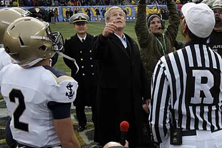 President George W. Bush flips a coin at the 50 yard line to start the 109th annual Army Navy football game in Philadelphia today.  (Laurence Kesterson / Staff
Photographer)