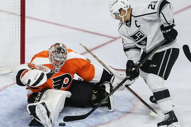 Steve Mason stops the puck of the Kings' Dustin Brown.