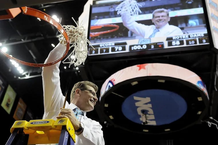 Connecticut head coach Geno Auriemma raises the net after a 79-58 victory against Notre Dame in the NCAA women's National Championship game at the Bridgestone Arena in Nashville, Tenn., on Tuesday, April 8, 2014.(John Woike/Hartford Courant/MCT) PHILLYHOOPS-cc