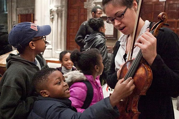 Angela Sulzer gives the children a close look at her violin. 
(Photo credit: Dana Scherer)