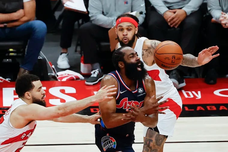 Sixers guard James Harden loses the basketball after getting fouled against Toronto Raptors guard Gary Trent Jr., (right) and guard Fred VanVleet in the second quarter during game four of the first-round Eastern Conference playoffs on Saturday, April 23, 2022 in Toronto.
