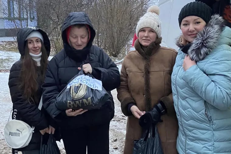 Ukrainian volunteer Alena Prizhebolska (in blue jacket) and her team, funded by the U.S. charity, Ukraine TrustChain, deliver food and medicine to Kherson residents newly liberated from Russian occupation.
