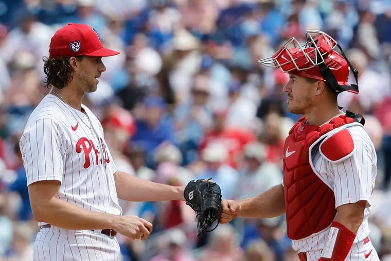 Phillies starting pitcher Aaron Nola touches catcher J.T. Realmuto’s glove before Nola got replaced in the sixth inning.