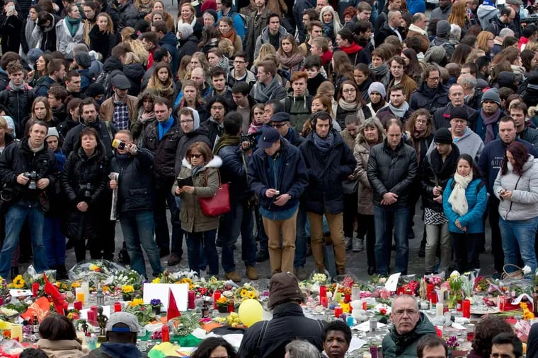 People observe a minute of silence at the Place de la Bourse in Brussels Thursday.