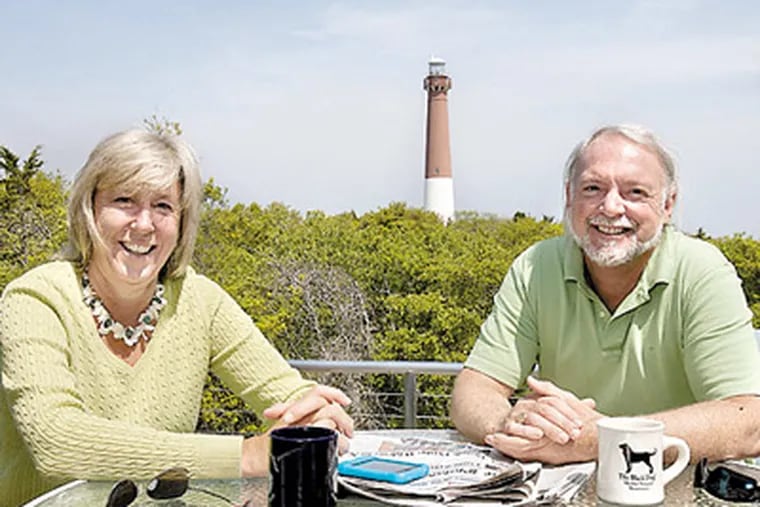 Sarah Ann Miller and Dave Bossi on the third-floor balcony of their Barnegat Light home, with the lighthouse as a backdrop. Other spots in the house, a 1 1/2-year project, offer views of the inlet and the state park. (Akira Suwa / Staff Photographer)