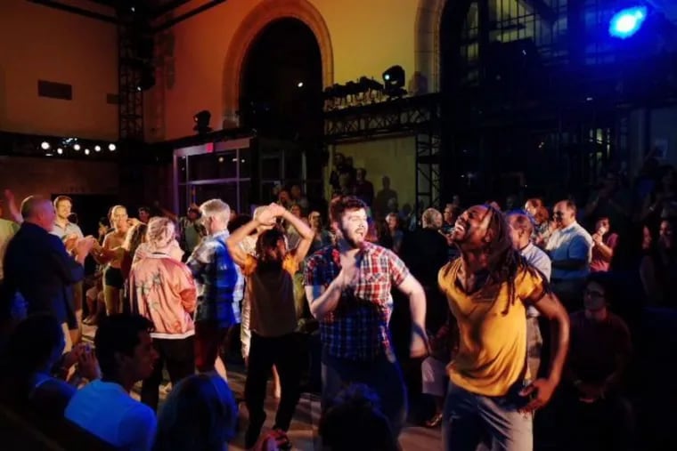 Performers, Christopher Roche and Jaymes Williams dance with the audience at the finale of the epic installation “This Is Reading,” July 21-23 and July 28-30 at the Franklin Station, Reading.