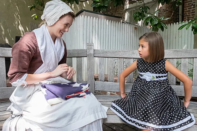 On the story telling bench at the Betsy Ross house, Joanna Harris and "history maker" Meredith LaBoon who portrays Betsy Ross, exchange stories. ( ED HILLE / Staff Photographer )