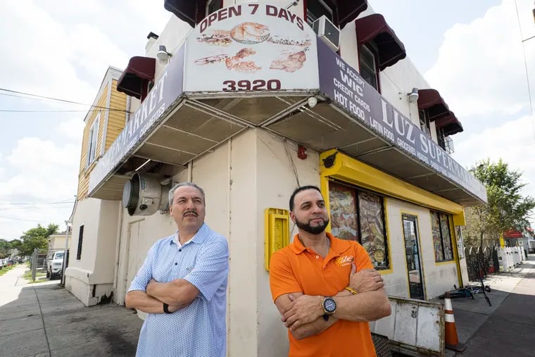 Obed Borrayes, member of La Asociacion de Empresarios Unidos, left, and Franklin Hernandez, president of the association of Camden grocers, pose for a photo at Hernandez’s Luz Supermarket store in Pennsauken, N.J. on Tuesday, August 30, 2022.