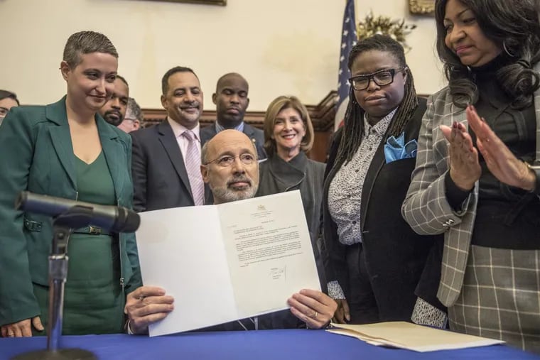 Surrounded by supporters, Pennsylvania Governor Tom Wolf holds up his signed veto of Senate Bill 3, legislation that would ban abortion after 20 weeks gestation.