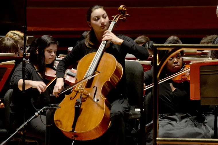 Cellist Eliana Yang, winner of All City's concerto competition, plays as Nanette Foley leads the orchestra.