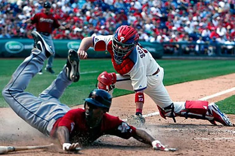 Michael Bourn slides past Brian Schneider's tag in the seventh inning. (Ron Cortes/Staff Photographer)