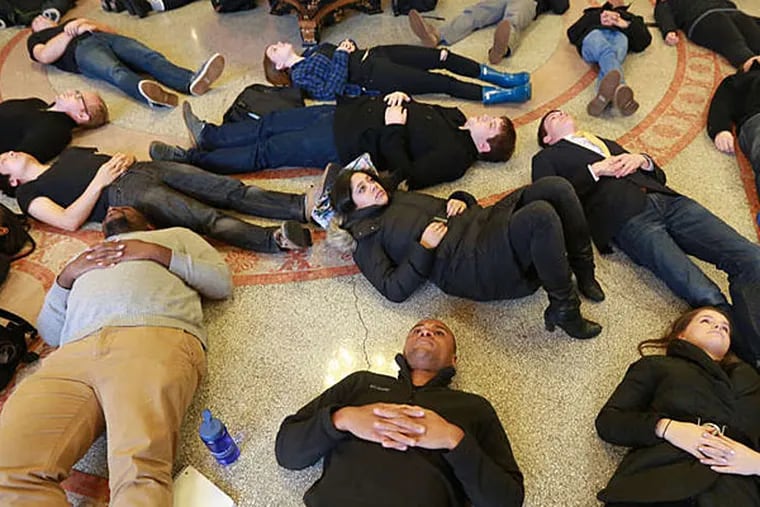 About 60 students at Penn Law School hit the floor for 41/2 minutes Tuesday to protest the Michael Brown case. (DAVID SWANSON / Staff Photographer)