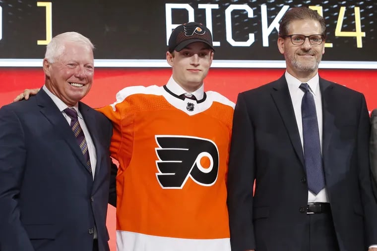 Joel Farabee (center) stands on stage after being drafted by the Flyers.