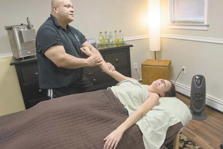 Massage therapist Roger Ortiz gives a therapeutic massage to Lyssa Nestoras-Soulis of Magnolia at his office in Discover Chiropractic Center, Blackwood, February 1, 2013.   ( DAVID M WARREN / Staff Photographer )