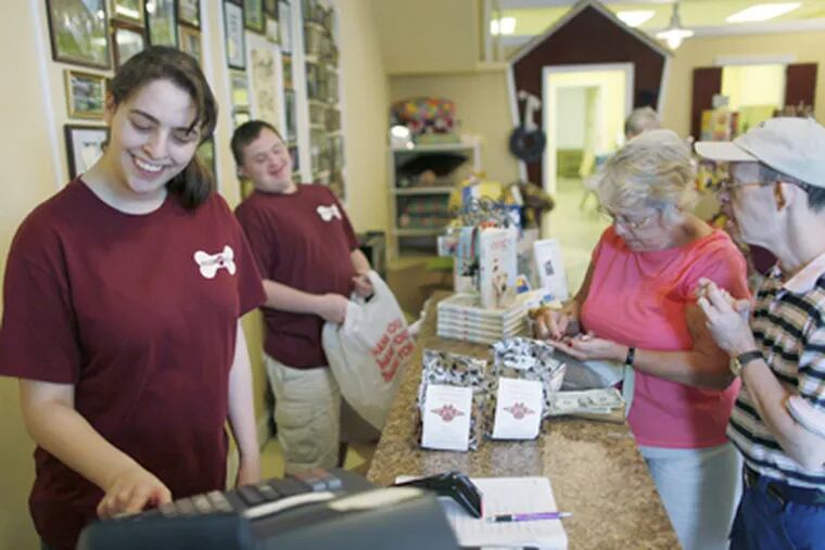 Alicia Headley rings up the sale as Michael Hoffman bags the purchases of Barbara Haney and her son Clinton Hatcher at Pride Paws in Medford. (Michael S. Wirtz / Staff Photographer)