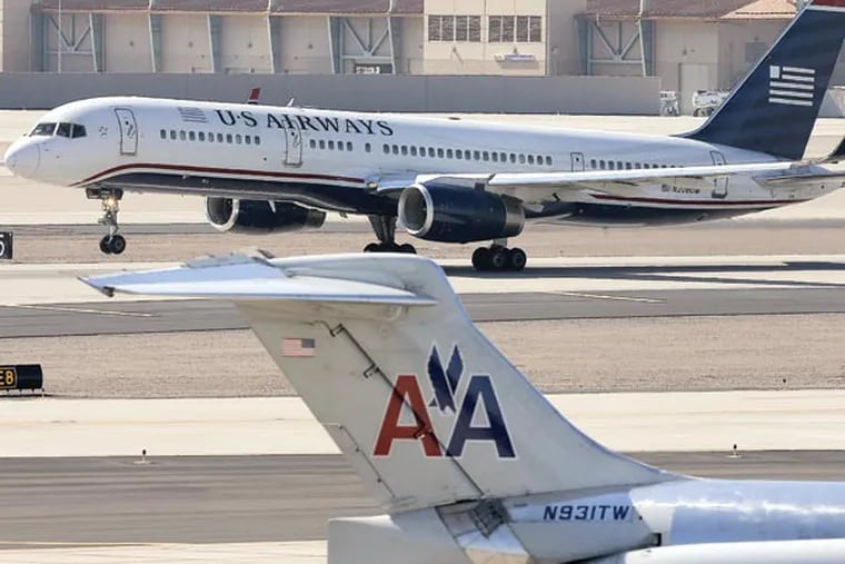 FILE - In this Thursday, Feb. 14, 2013, file photo, a U.S. Airways jet passes an American Airlines jet at Sky Harbor International Airport in Phoenix. The merger of the two airlines has given birth to a mega airline with more passengers than any other in the world. The Justice Department and a number of state attorneys general on Tuesday, Aug. 13, 2013,  challenged a proposed $11 billion merger between US Airways Group Inc. and American Airlines' parent company, AMR Corp. (AP Photo/Matt York, file)