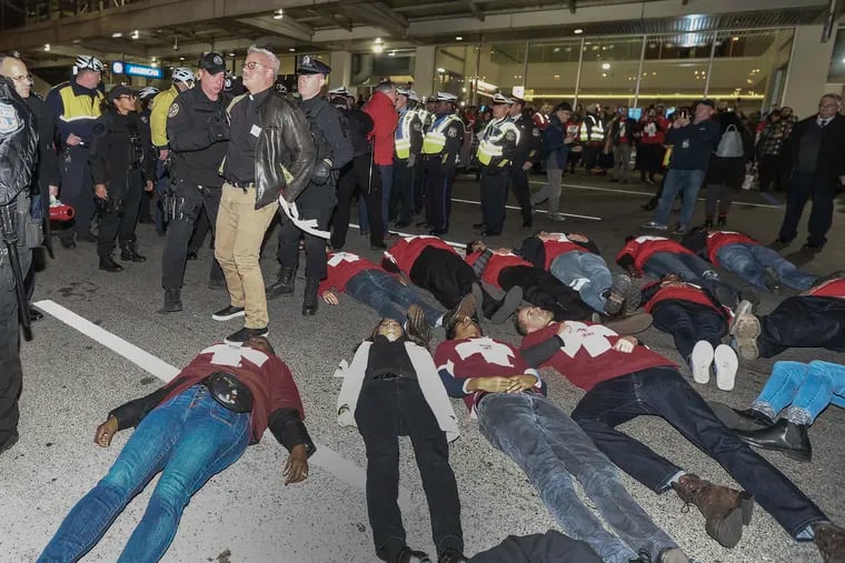 Protesters march in front of American Airline at terminal C. Airline caterers, represented by union UNITE HERE, and their supporters are protesting high health coverage costs and low wages. Some 39 protesters were arrested for lying down blocking the roadway in front of the terminal. Tuesday,  November 26, 2019.