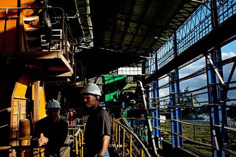 Workers stand among the machinery inside the 5th of September Sugar Mill in Cienfuegos, Cuba, on Monday, Dec. 29, 2014. U.S. plans to normalize ties with Cuba may present opportunities for U.S. agricultural and packaged-food companies over time. Photographer: Bloomberg