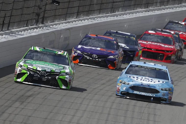 Kyle Busch, left, races Kevin Harvick into Turn 1 during a NASCAR Cup Series auto race at Michigan International Speedway in Brooklyn, Mich., Sunday, Aug. 12, 2018. (AP Photo/Paul Sancya)