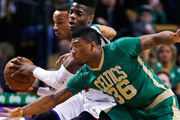 Philadelphia 76ers center Nerlens Noel is sandwiched between Boston
Celtics guards Marcus Smart (36) and Avery Bradley, rear, during the
first quarter of an NBA basketball game in Boston, Monday, March 16,
2015. (Charles Krupa/AP)
