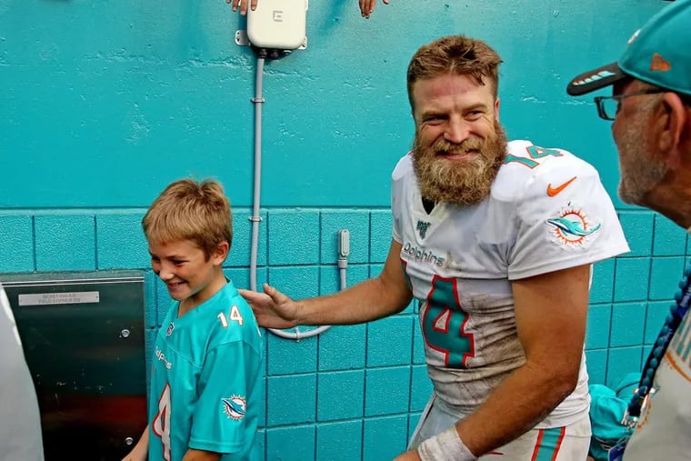 No kidding! Vegas Vic likes Ryan Fitzpatrick, shown here celebrating last week's win over the Jets with one of his sons, to cover a hefty spread against the Colts.