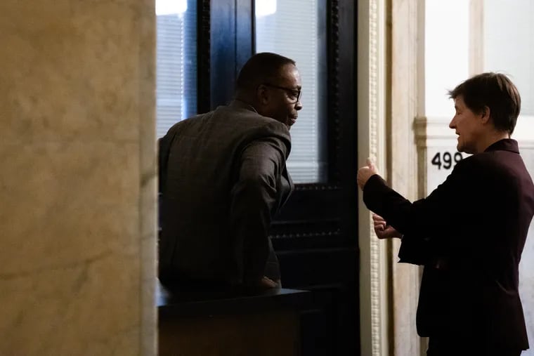 Anne Fadullon, director of the department of planning and development, speaks with City Council President Darrell L. Clarke outside a hearing on a bill to change the 10-year tax abatement at City Hall in 2019.