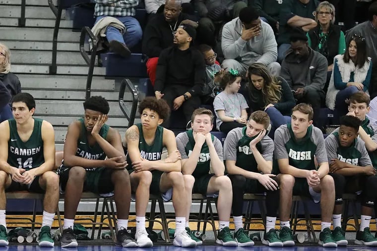 Camden Catholic coach Matt Crawford (standing) and players sit dejected near the end of their loss to Bergen Catholic on Saturday in the Non-Public A state final.