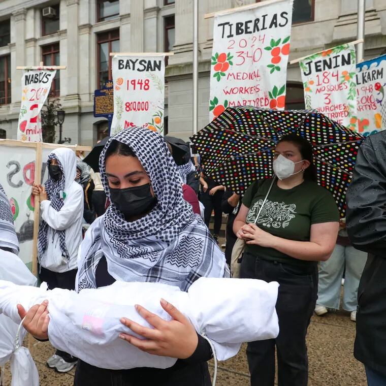 Pro-Palestine protesters hold figures representing children killed in Gaza, during a demonstration at Philadelphia City Hall on Saturday, May 18, 2024.
