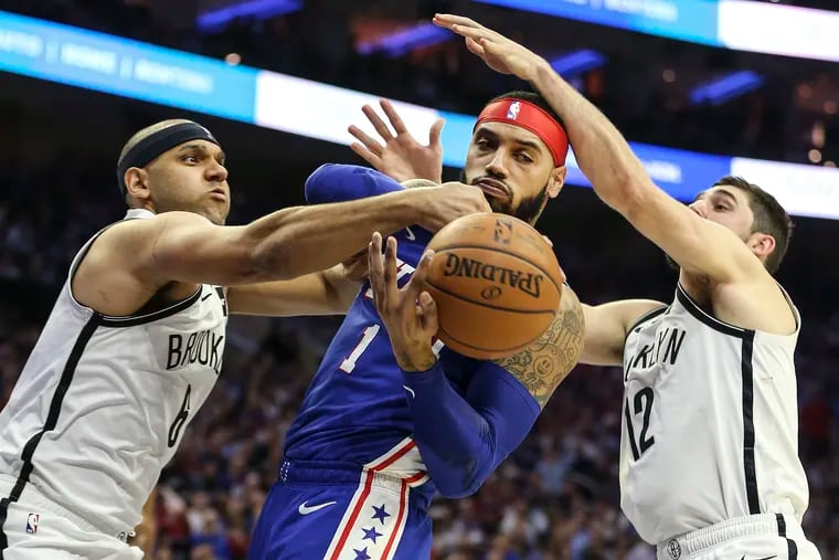 Mike Scott (middle) vying for a loose ball with the Nets' Jared Dudley and Joe Harris (right) during the second quarter of Game 5.