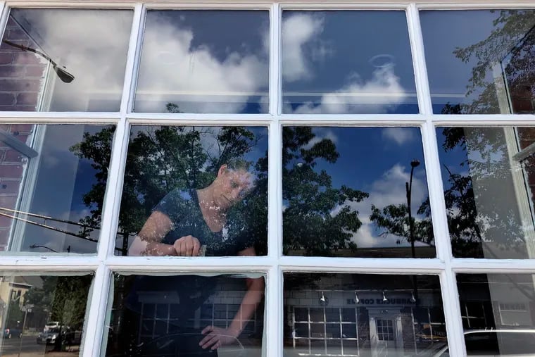 Felice Leibowitz works on the windows of The Little Hen, readying her French-inspired restaurant at Kings Highway and Haddon Avenue for a June 19 opening.