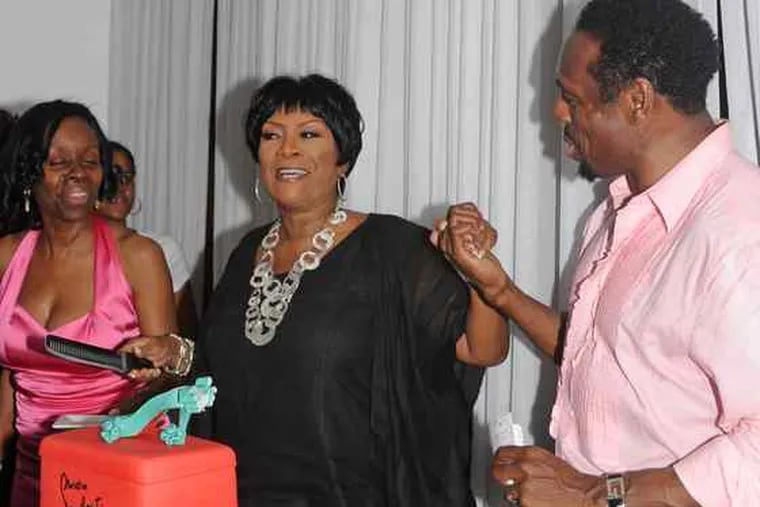 Patti LaBelle marks her 65th birthday with KeVen Parker (right) at his South Street restaurant, Ms. Tootsie's. The cake, created by Chestnut Hill's Night Kitchen Bakery to reflect LaBelle's love for footwear, was cut last Sunday.