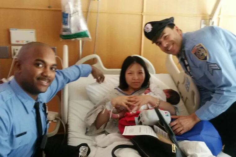 SEPTA Transit Police Officer Darrell James (left) and Sgt. Daniel Caban met with Yanjin Li and her son Kris today after helping bring the boy into the world on Christmas Day. (Courtesy: SEPTA)