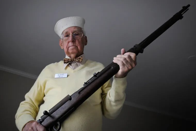 WWII vet Albert Moss, who ran a landing craft that took soldiers at Normandy, Iwo Jima and Okinawa holds a Japanese rifle and wears a sailor's hat he kept as souvenirs after the war. November 8, 2013 (RON TARVER/Staff Photographer)