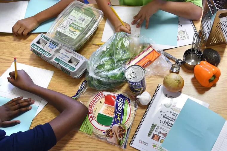 With the breakfast burrito ingredients meal ready to go, students at Cramer Elementary School in Camden begin the first of this semester's weekly cooking classes  by filling out their notebooks.