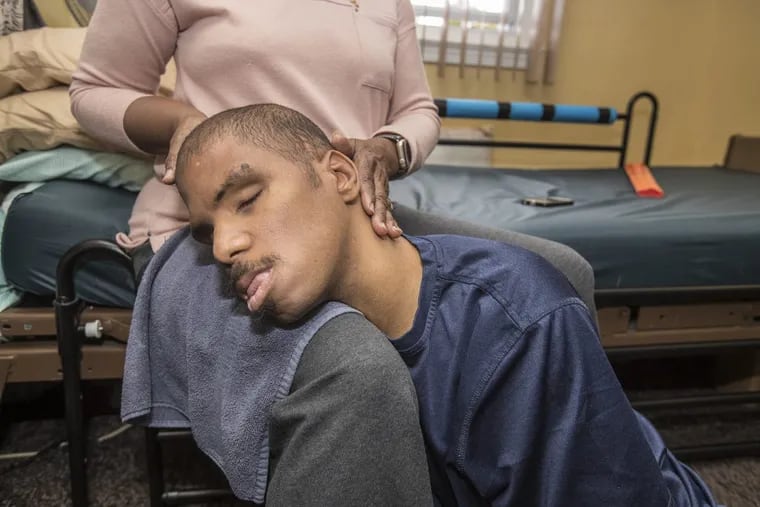 Justin Scott, 31, stops moving for a moment and allows his mother, Annette Scott, to rub his head in his room. Justin is blind, has cerebal palsey and is diagnosed autistic. His story was chronicled in “Falling off the Cliff.”