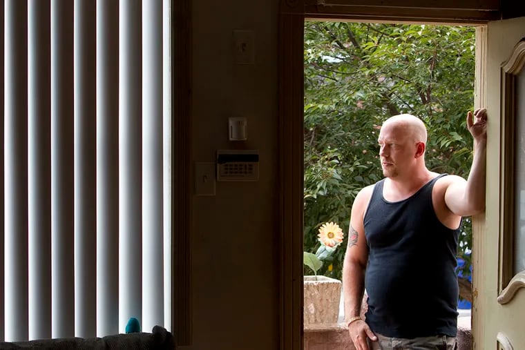 John Simmons stands in the doorway of a relatives home on Aug. 8, 2014.  On April 17, Simmons and his wife did heroin together and both overdosed. Paramedics managed to save him but she passed away.   ( CHARLES FOX / Staff Photographer )