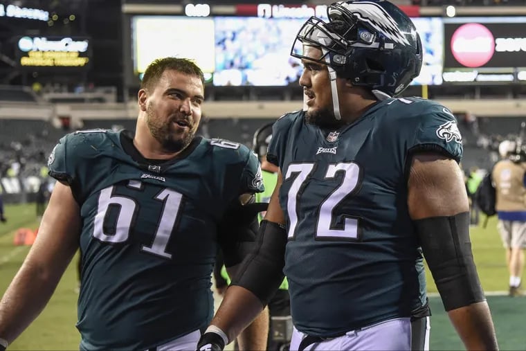 Eagles guard Stefen Wisniewski (left), walking off the field with Halapoulivaati Vaitai after an October game, will play Sunday.
