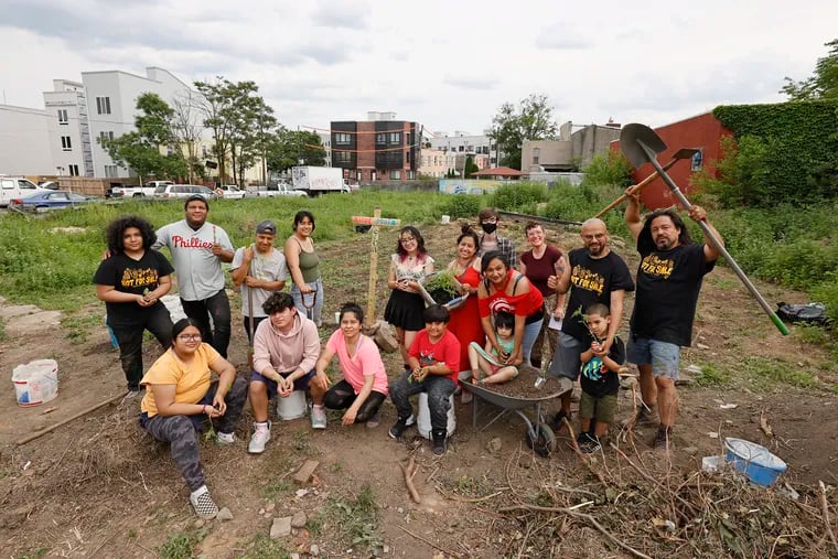 Folks take a break, from farming on a vacant lot, for a group photo next to the César Andreu Iglesias Community Garden in the West Kensington section of Philadelphia, on May 22, 2021.