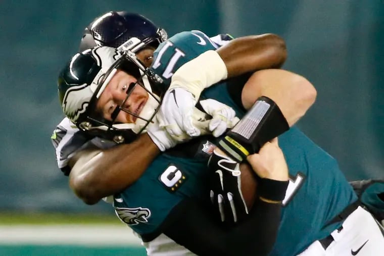 Eagles quarterback Carson Wentz gets taken down by Seattle Seahawks defensive end L.J. Collier during the fourth quarter on Monday.