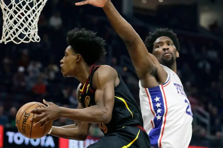 Cleveland Cavaliers' Collin Sexton, left, drives to the basket against Philadelphia 76ers' Joel Embiid in the first half of an NBA basketball game, Wednesday, Feb. 26, 2020, in Cleveland. (AP Photo/Tony Dejak)