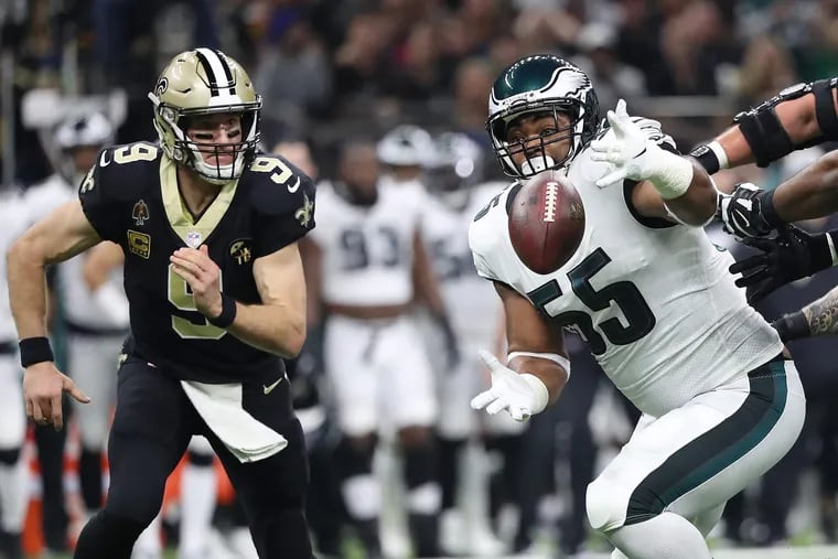New Orleans Saints quarterback Drew Brees, left, watches as Eagles defensive end Brandon Graham, center, tries to grab a loose ball in the 2nd quarter. The Saints recovered. Philadelphia Eagles play the New Orleans Saints in the NFL Divisional Round playoff game in New Orleans, LA on January 13, 2019.