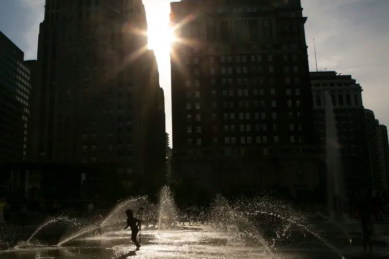 Kids are silhouetted as they play in the water fountain at LOVE Park in Center City, Philadelphia on Wednesday evening, July 17, 2019. Philadelphia and the region is currently in a heatwave that is expected to last until Sunday, with temperatures expected to reach the high 90s and low 100s.