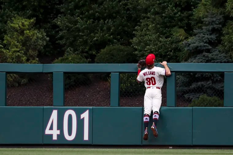 The Phillies' Luke Williams watches a home run by San Diego's Manny Machado fly over the center-field wall during the first inning of Sunday's game.