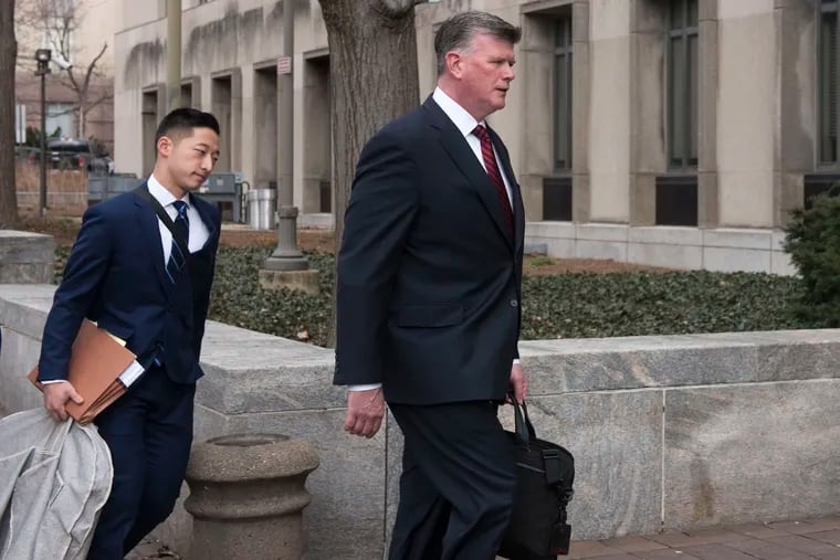 Kevin Downing (right), Paul Manafort's defense attorney, walks to the entrance of federal court on Wednesday in Washington. At left is attorney Tim Wang, another member of Manafort's defense team.
