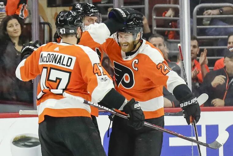Flyers center Claude Giroux (right) celebrates is second-period goal with center Sean Couturier and defenseman Andrew MacDonald (left).